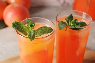 Photo of Tasty freshly made grapefruit juice with mint on table, closeup