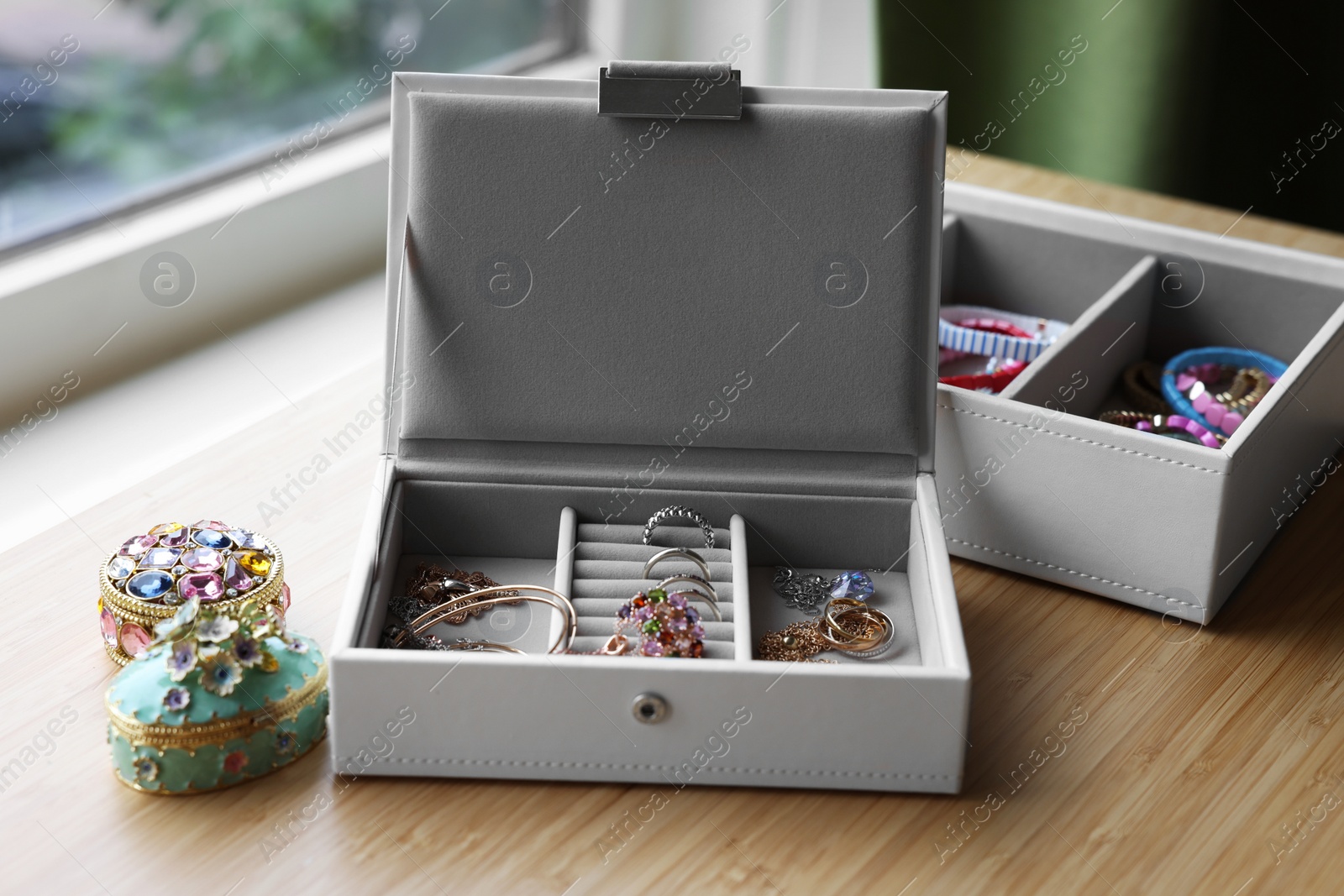 Photo of Jewelry boxes with many different accessories on wooden table