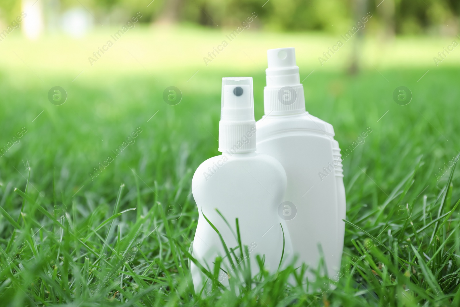 Photo of Bottles of insect repellent on green grass