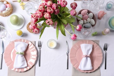 Festive table setting with beautiful flowers, flat lay. Easter celebration