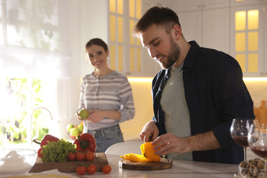 Lovely young couple cooking together in kitchen