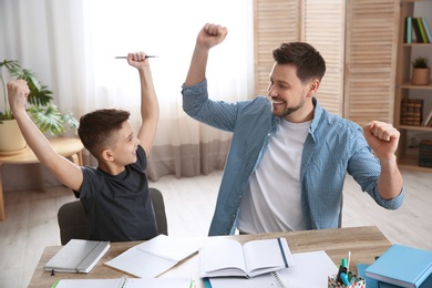 Photo of Happy dad and son after finishing homework in room