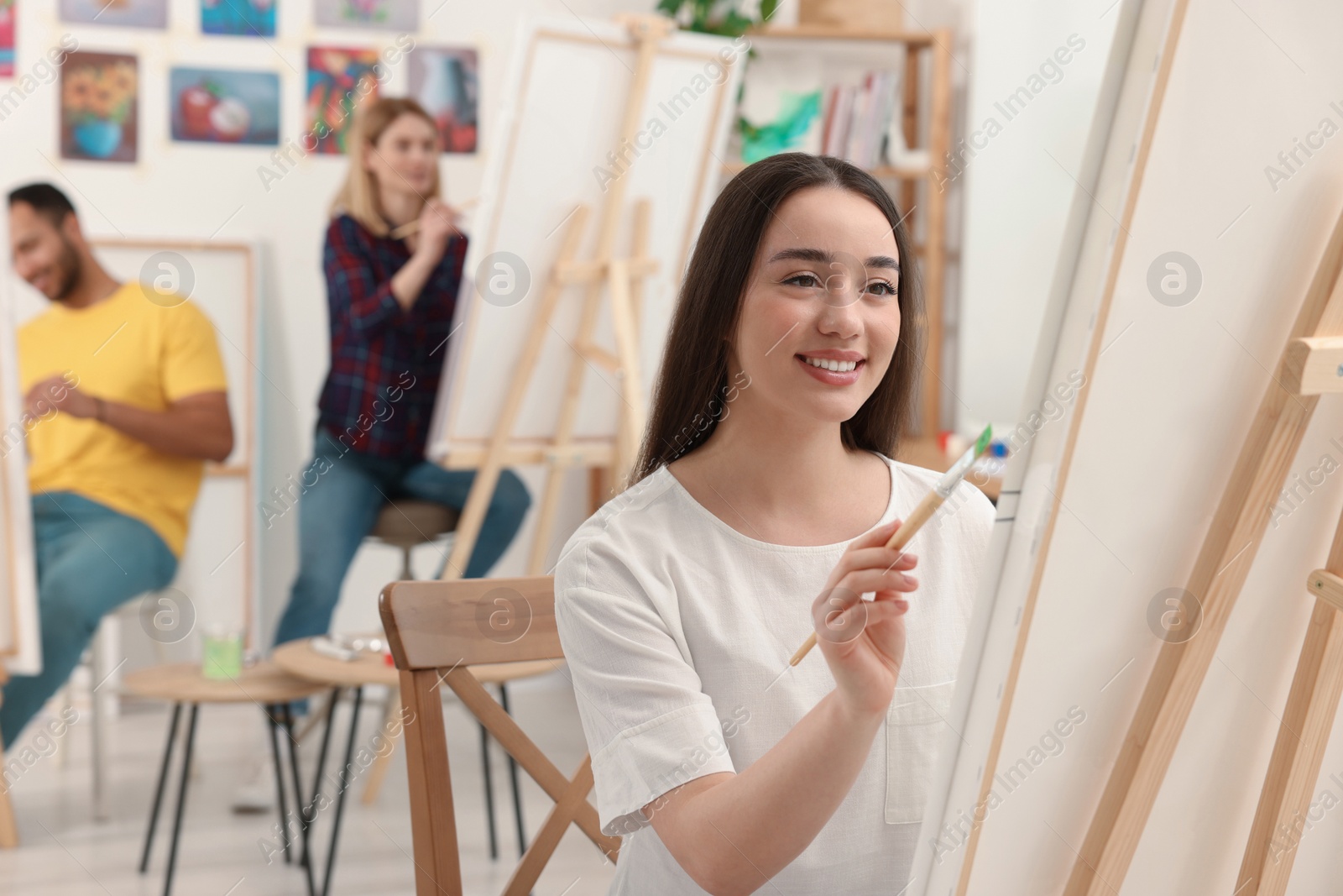 Photo of Group of students attending painting class in studio. Creative hobby