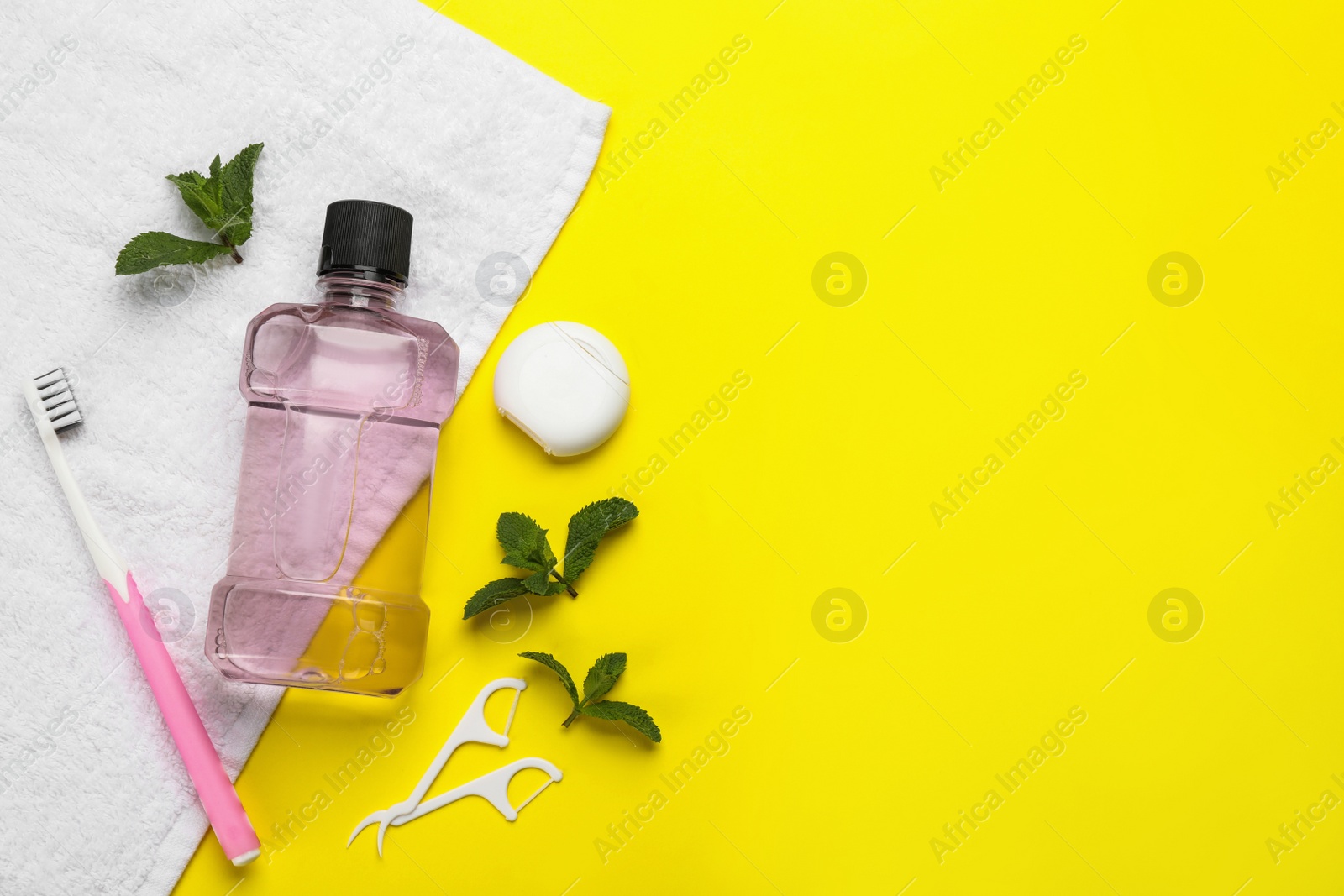 Photo of Flat lay composition with mouthwash and other oral hygiene products on yellow background. Space for text