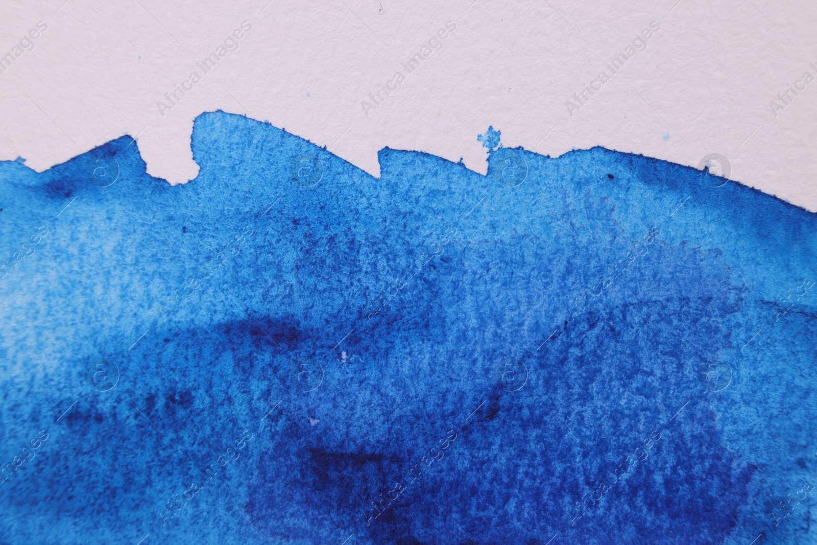 Photo of Abstract blue watercolor painting on white paper, top view