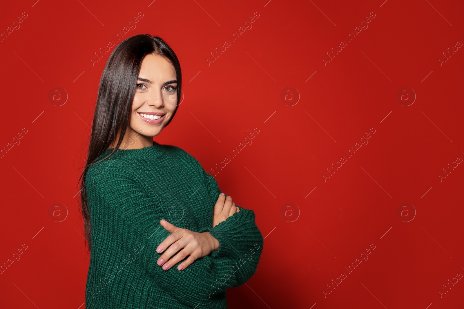 Image of Happy young woman wearing warm sweater on red background. Space for text