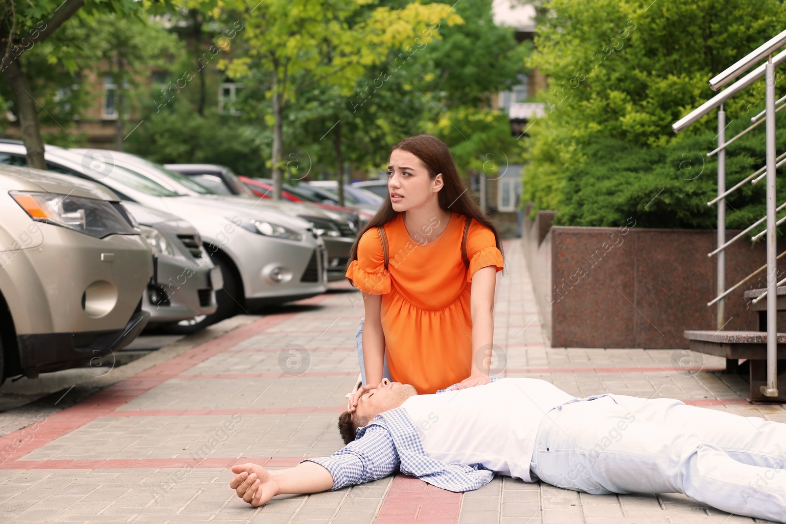 Photo of Passerby helping man with heart attack outdoors