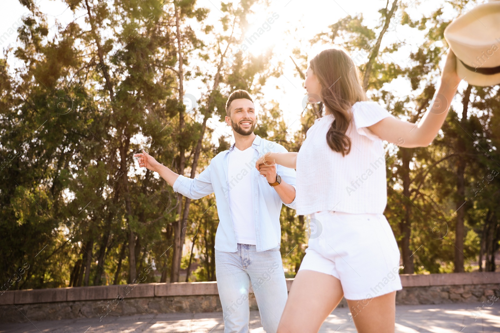 Photo of Lovely young couple dancing together outdoors on sunny day