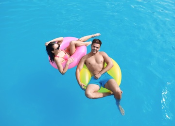Photo of Woman in bikini with boyfriend swimming at resort. Happy young couple