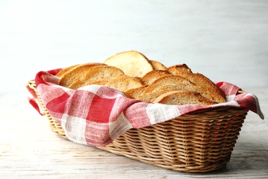 Photo of Slices of toasted bread in basket on white wooden table