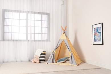 Photo of Cozy child room interior with play tent near window