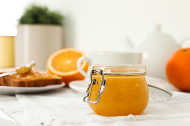 Photo of Delicious orange marmalade on table, closeup. Space for text