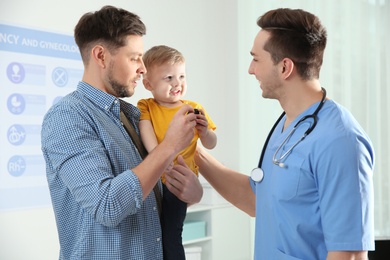 Photo of Father with child visiting doctor in hospital
