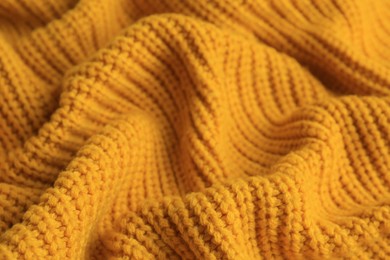 Beautiful orange knitted fabric as background, closeup