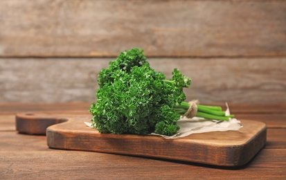 Photo of Board with fresh green parsley on table