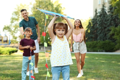 Photo of Happy family with children spending time together in green park on sunny day