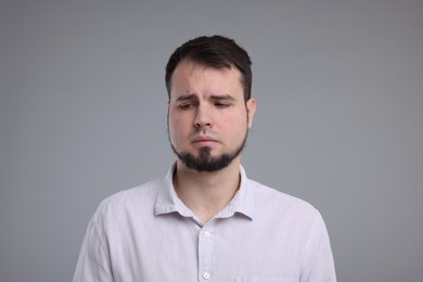 Photo of Portrait of sad man on grey background