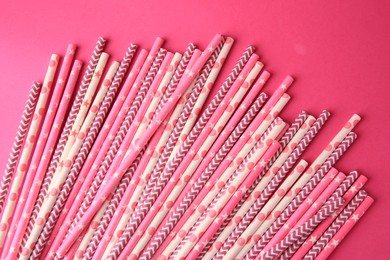 Many paper drinking straws on pink background, flat lay