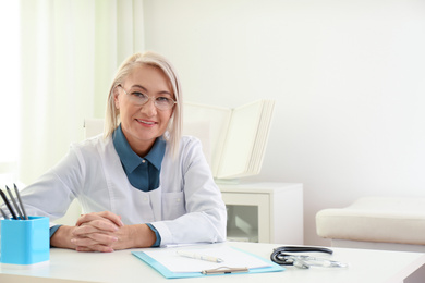 Photo of Portrait of mature female doctor in white coat at workplace