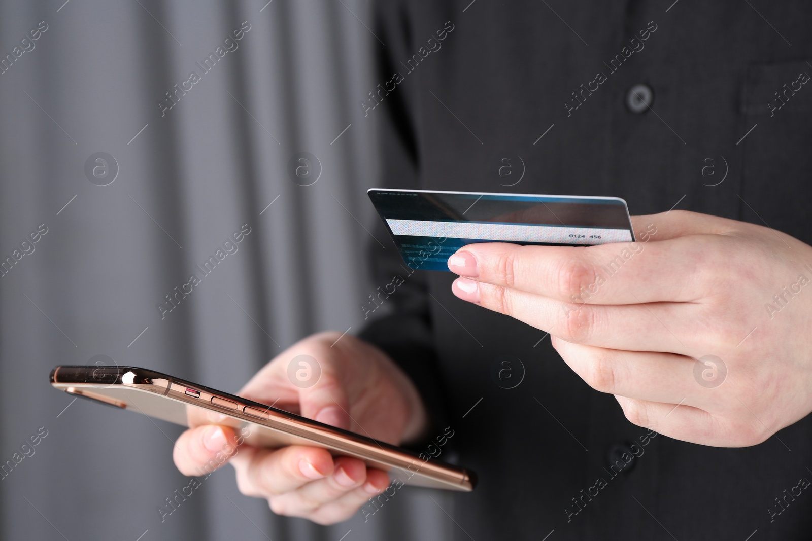 Photo of Online payment. Woman with smartphone and credit card indoors, closeup