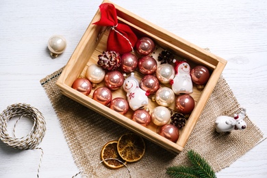 Flat lay composition with Christmas baubles on white wooden table