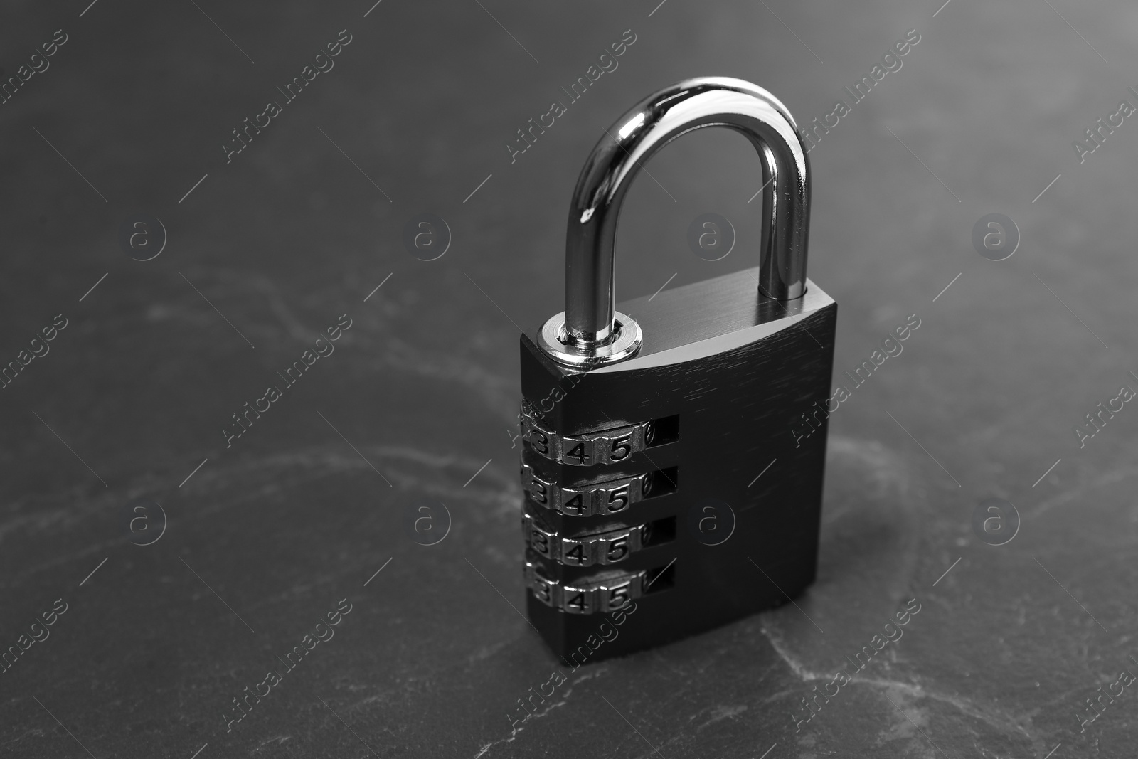 Photo of One steel combination padlock on black table, closeup