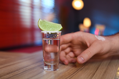 Photo of Man with shot of Mexican Tequila at bar, closeup