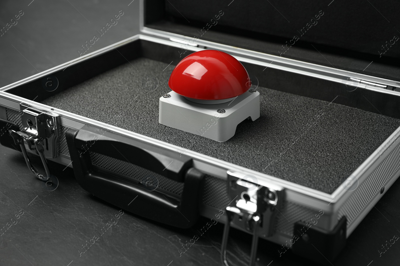 Photo of Red button of nuclear weapon in suitcase on black background. War concept