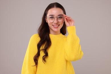 Photo of Beautiful young woman in stylish warm sweater on grey background