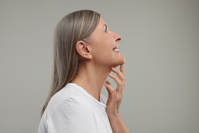 Beautiful woman with healthy skin on grey background