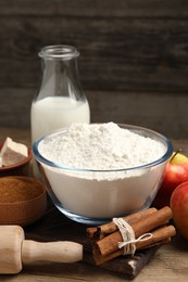 Photo of Flour, milk and different ingredients on wooden table. Cooking yeast cake