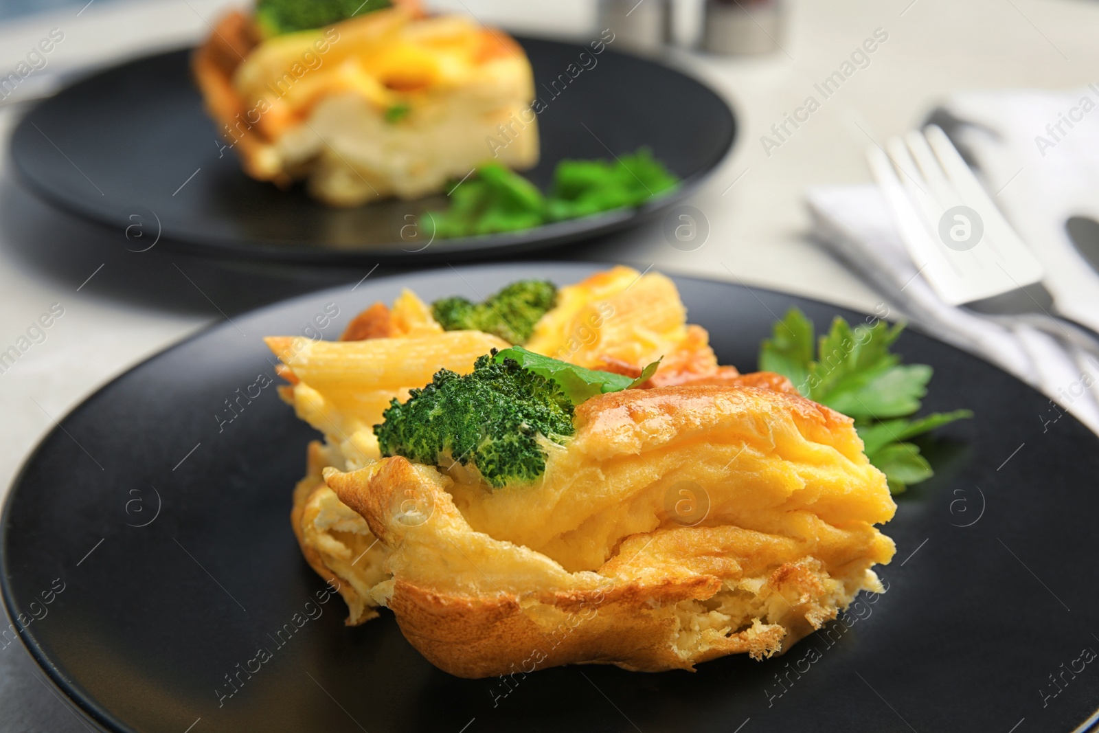 Photo of Tasty broccoli casserole on dark plate, closeup