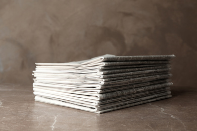 Photo of Stack of newspapers on marble table. Journalist's work