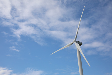 Wind turbine against beautiful blue sky. Alternative energy source