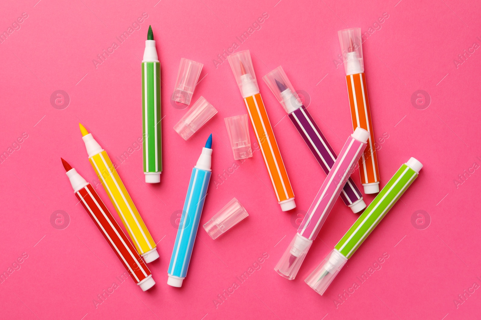 Photo of Many bright markers on pink background, flat lay