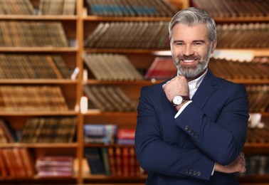 Successful lawyer against shelves with books, space for text