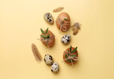 Photo of Festively decorated eggs on yellow background, flat lay. Happy Easter