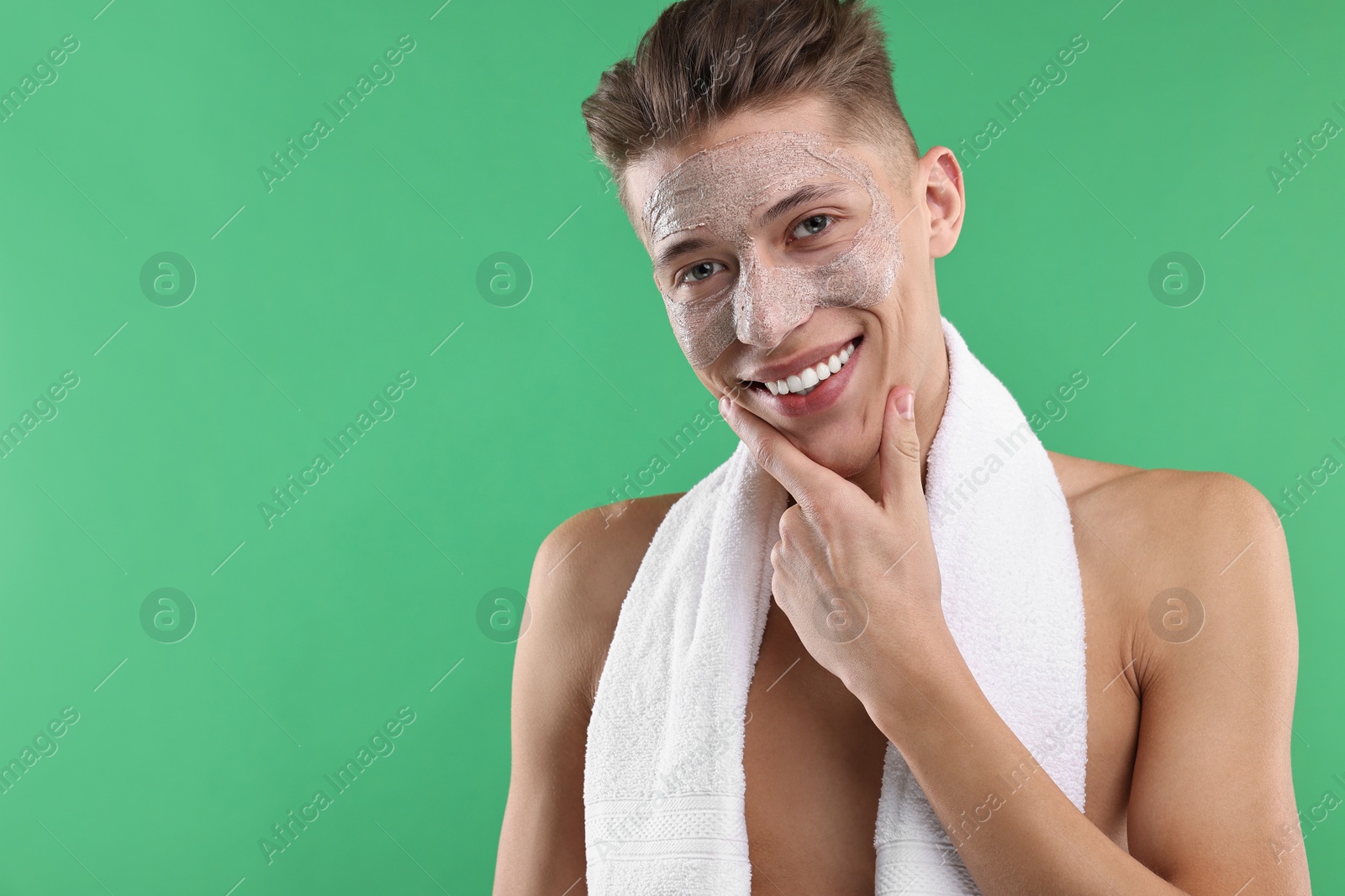 Photo of Handsome man with facial mask on his face against green background. Space for text