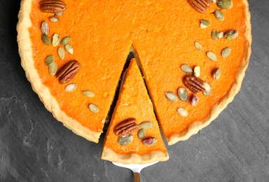 Photo of Delicious homemade pumpkin pie on black table, top view