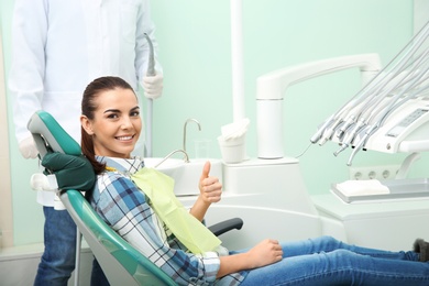Photo of Happy young woman and dentist in modern clinic