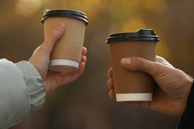 Photo of Couple with takeaway coffee cups outdoors, closeup
