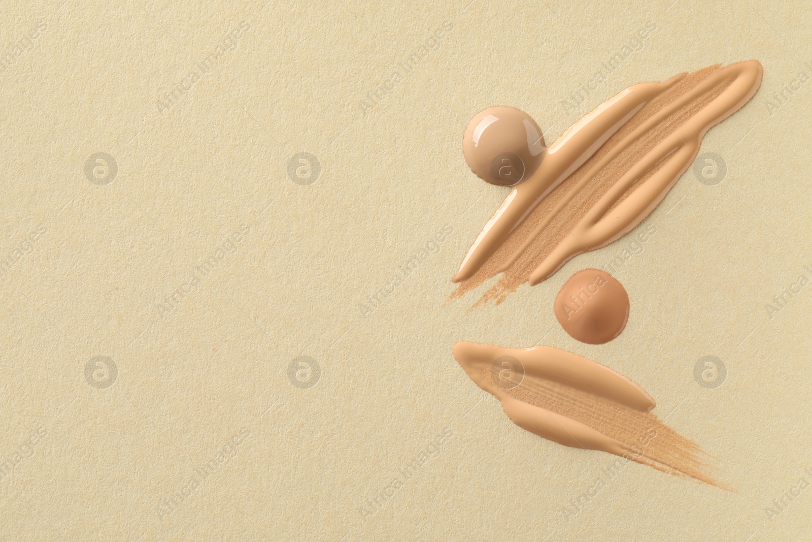 Photo of Samples of liquid skin foundations on beige background, top view. Space for text