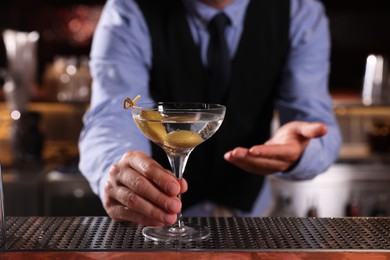 Photo of Bartender with fresh alcoholic cocktail in bar, closeup