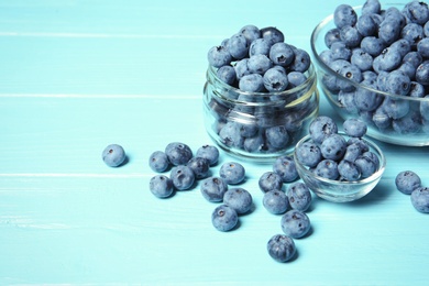 Photo of Glassware with juicy and fresh blueberries on wooden table. Space for text