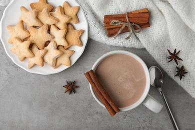 Composition with delicious hot cocoa drink and cookies on grey background, flat lay