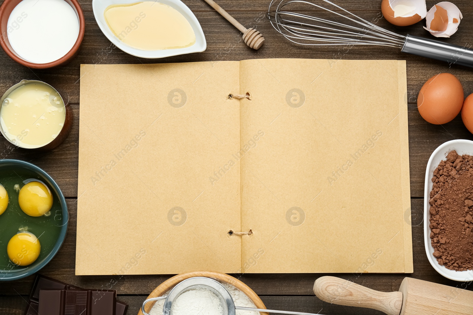 Photo of Blank recipe book and different ingredients on wooden table, flat lay. Space for text