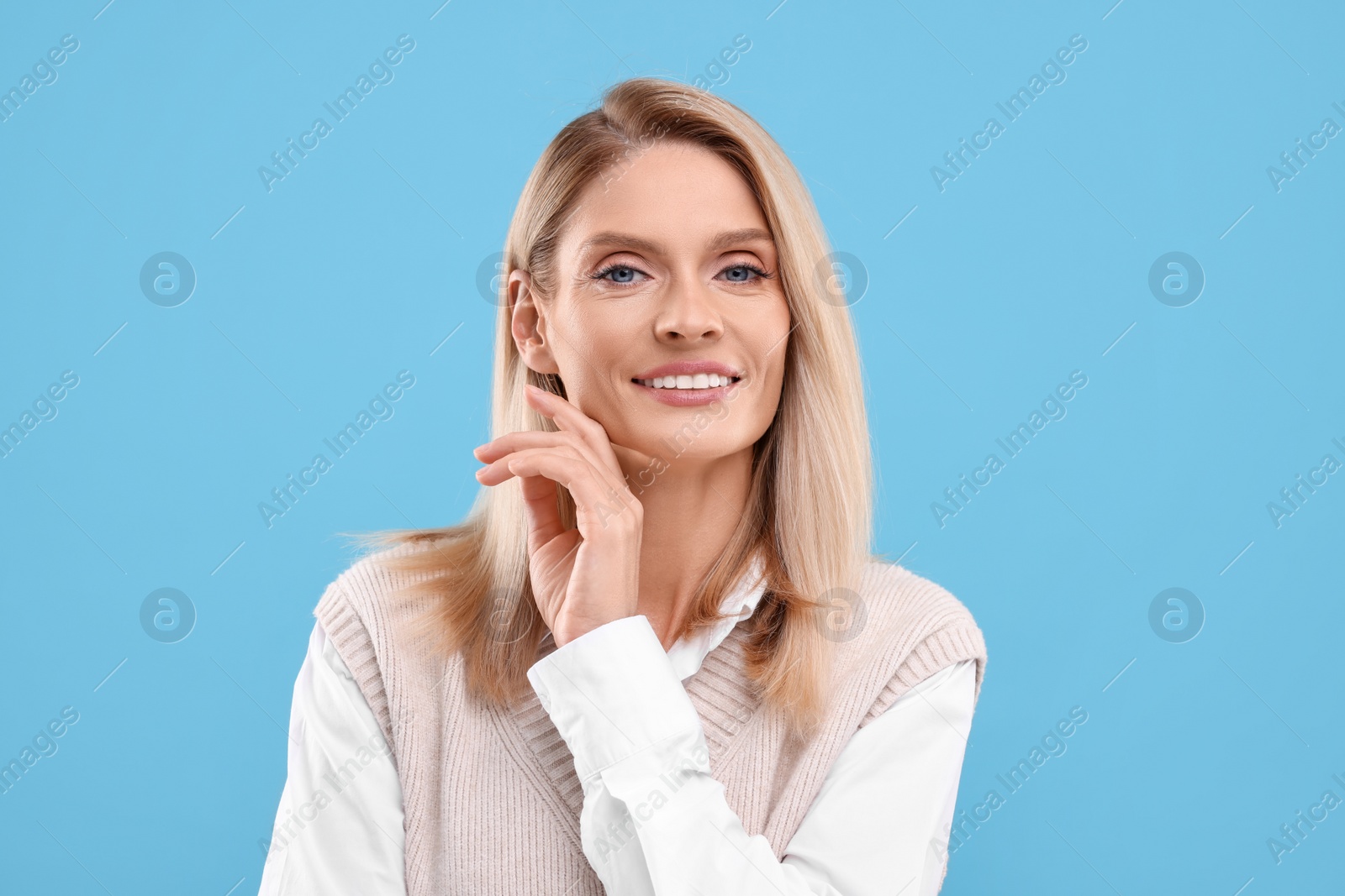 Photo of Portrait of smiling middle aged woman on light blue background