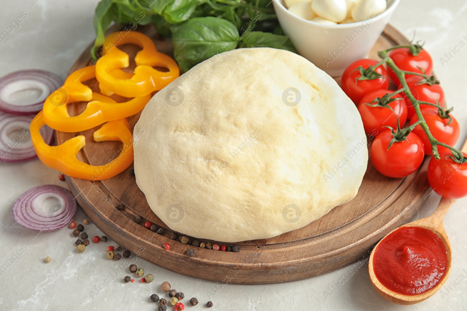 Photo of Fresh dough and ingredients for pizza on table