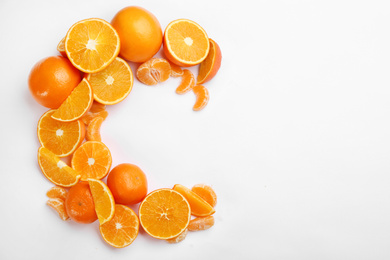 Photo of Letter C made with citrus fruits on white background as vitamin representation, top view