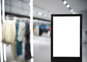 Image of Blank advertising board in clothing store. Mockup for design